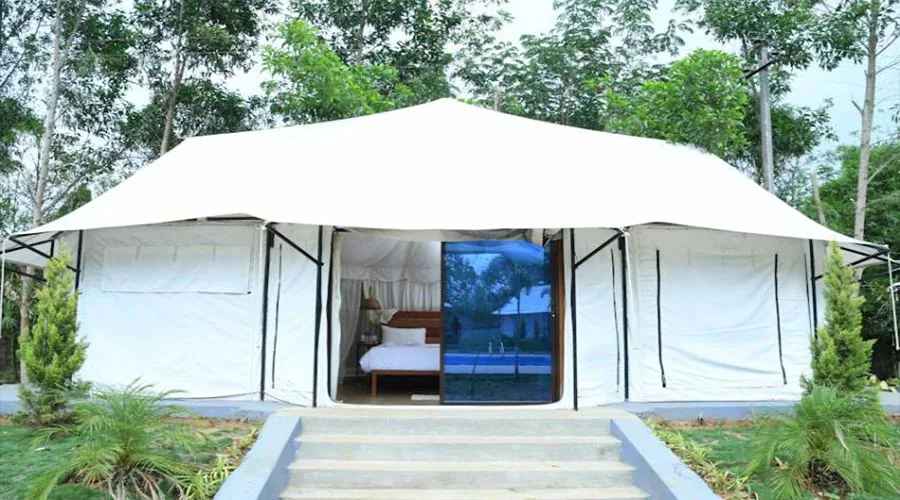Luxury white glamping tent with glass doors at Century Resort Dandeli