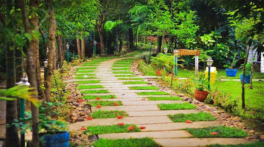 Garden path with Restaurant sign at Century Resort Dandeli, Kogilban