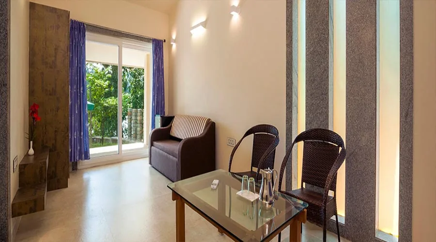 Cottage living room with garden view at Whistling Woods Dandeli