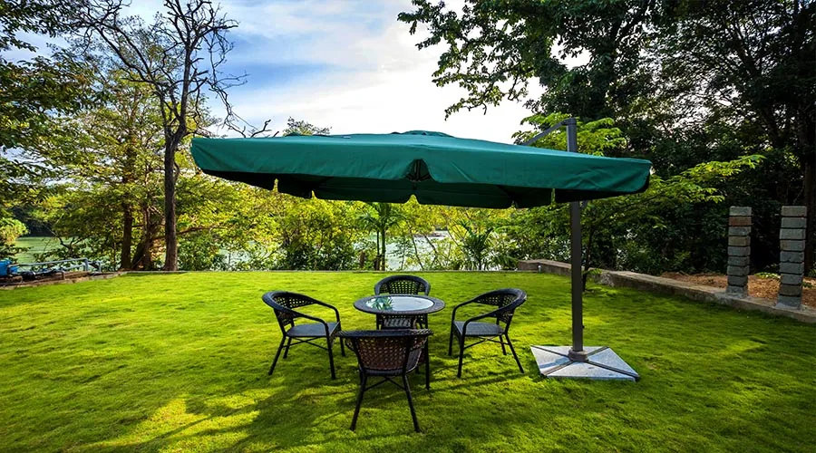 Lawn seating under umbrella overlooking the Kali at Whistling Woods Dandeli