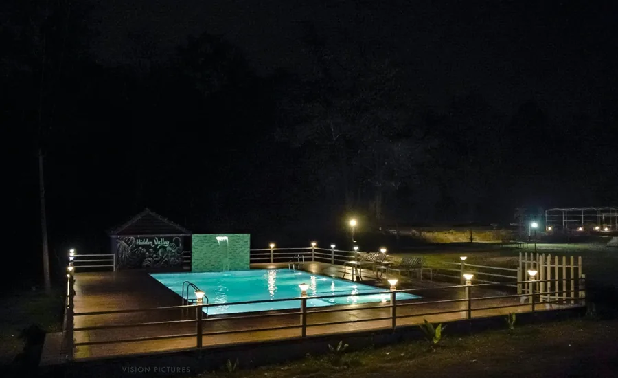 Night swimming pool with Hidden Valley signage at Hidden Valley Dandeli