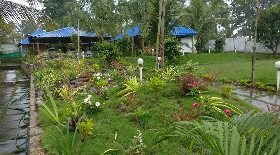 Landscaped gardens and blue-roof buildings at Jungle Bell River Resort