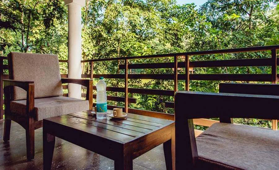 Private balcony overlooking forest at Parampara Cottages