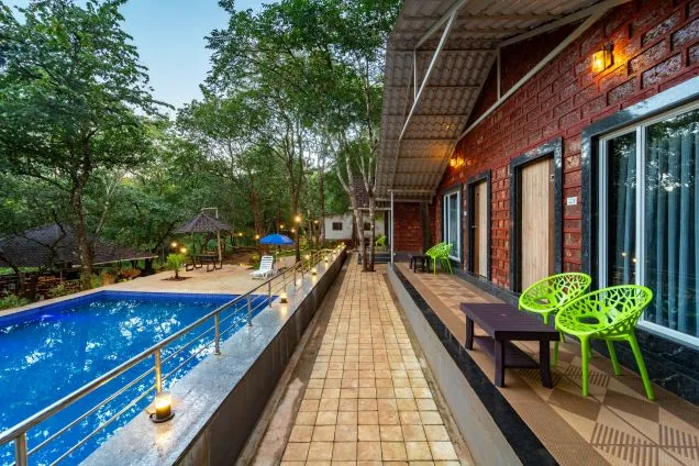Cottage verandah beside the pool at Rain Forest Dandeli