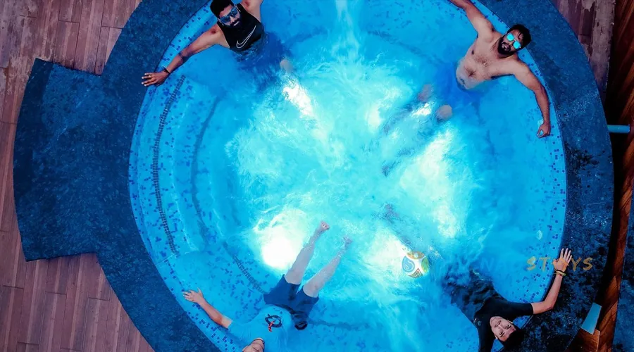 Circular lit jacuzzi at night at Woodpecker Homestay Dandeli