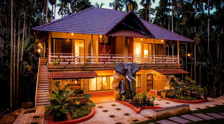 Evening cottage facade with elephant sculpture at Woodpecker Homestay Dandeli